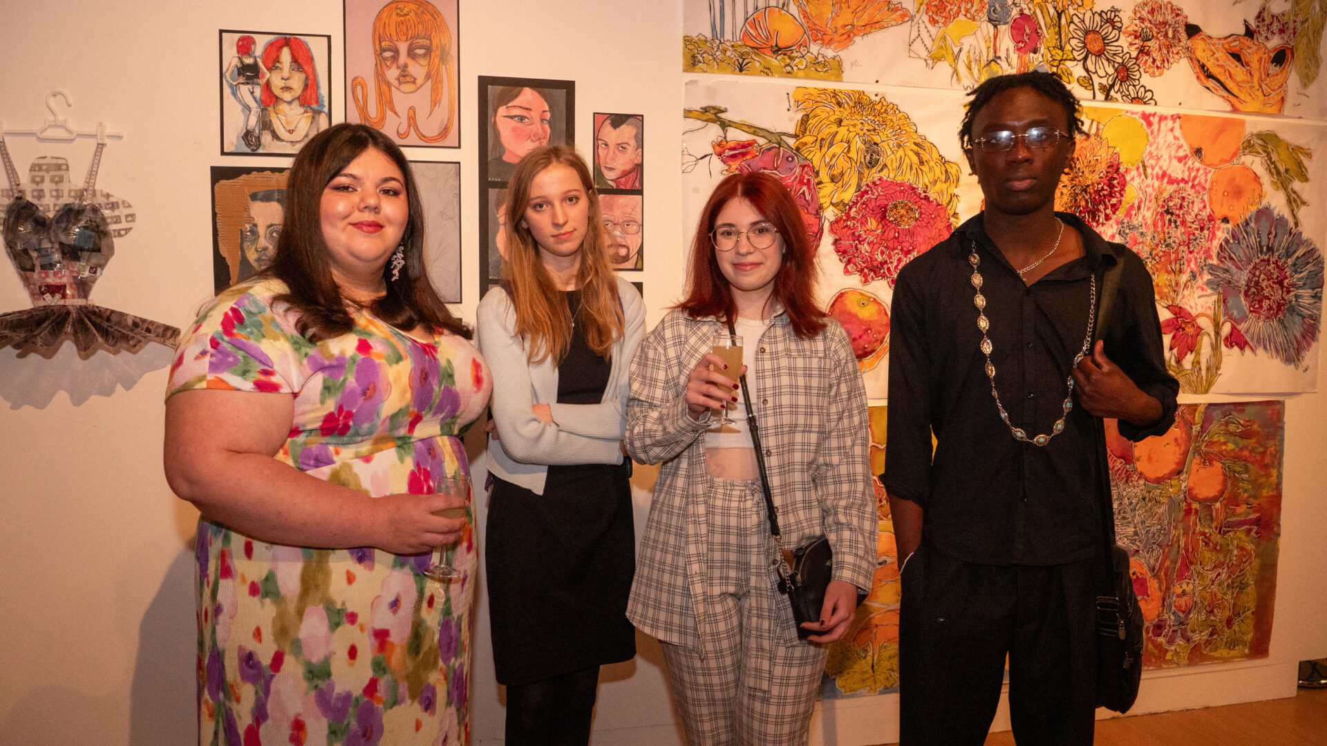 Four students standing in front of their artwork.