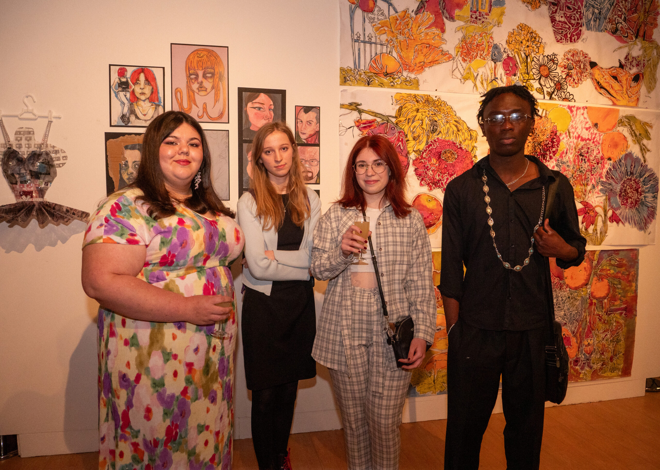 Four students standing in front of their artwork.